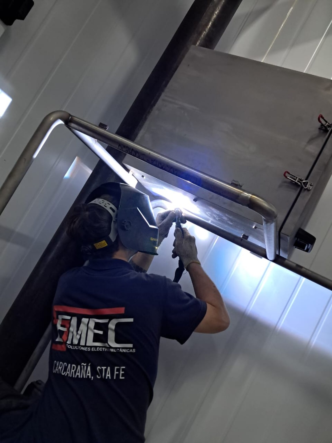 Integrante de Semec realizando soldadura en acero inoxidable sobre un soporte industrial